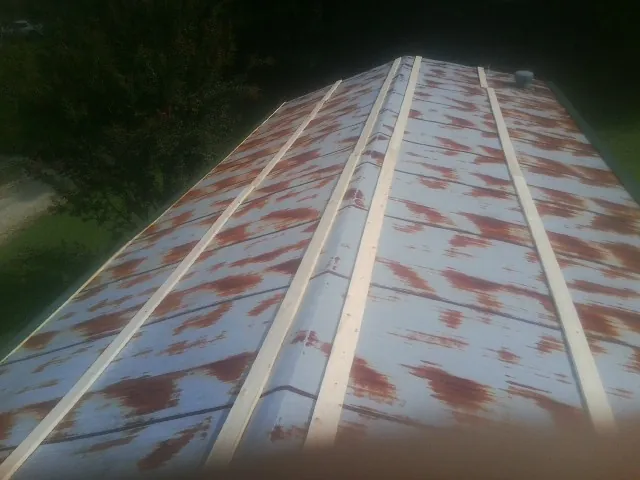 Rusted metal roof panels with new wood purlins before replacement — Storm Damage Roof Repair in Osteen by Roofing Brothers